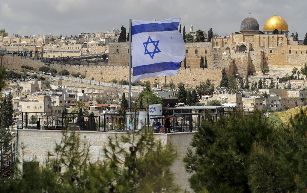 Le 9 avril 2021, un drapeau israélien flotte au-dessus d'une maison récemment habitée par des soldats juifs, dans le quartier à prédominance arabe de Jérusalem-Est annexé par Israël, face à la vieille ville et à ses vestiges historiques. AHMAD GHARABLI / AFP