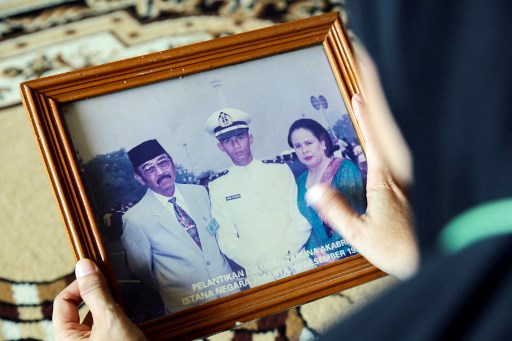 Un membre de la famille tient une photo du colonel de marine Harry Setiawan, commandant du sous-marin KRI Nanggala (402) de la marine qui a disparu au large de Bali le 21 avril lors d'un exercice d'entraînement à Depok le 24 avril 2021. (Rayi Gigih / AFP)