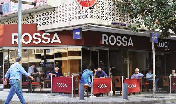 Des clients portant un masque en raison de la pandémie de coronavirus (Covid-19) sont assis dans un café situé dans le quartier Hamra à Beyrouth, la capitale du Liban. (Fichier/AFP)