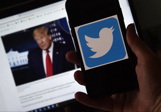 Le logo de Twitter sur un portable, avec une photo du président Trump en arrière-plan, le 27 mai 2020, à Arlington, en Virginie. (AFP/File Photo)