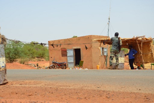 Un policier armé monte la garde le 19 juin 2019 au poste de contrôle de la police où deux policiers ont été tués et quatre blessés par des hommes armés lors d'une attaque nocturne le 18 juin au commissariat à l'entrée nord de Niamey (Photo, AFP)