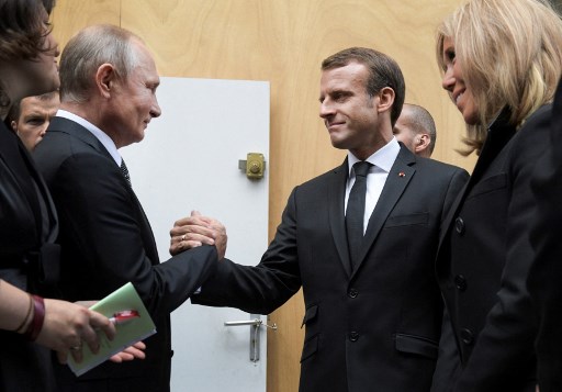 Le président russe Vladimir Poutine (g) serre la main de son homologue français Emmanuel Macron à côté de Brigitte Macron après avoir assisté à un service religieux pour l'ancien président français Jacques Chirac à l'église Saint-Sulpice à Paris, le 30 septembre 2019. Alexei Druzhinin/Spoutnik/AFP)