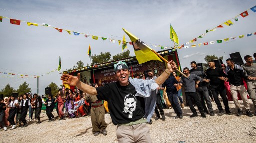 Un homme portant les couleurs du Parti des travailleurs du Kurdistan (PKK), Abdullah Ocalan, danse lors d'une célébration du deuxième jour de Norouz, le nouvel an persan, dans la province syrienne de Hasakah, près de la frontière avec la Turquie, le 21 mars 2021.(Delil Souleiman/AFP)
