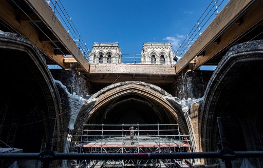 Un ouvrier se tient sur un échafaudage sous la voûte de la cathédrale Notre-Dame de Paris avant une visite du président français deux ans après l'incendie qui a fait s'effondrer la flèche et détruit une grande partie du toit, à Paris le 15 avril 2021 (Photo, AFP)