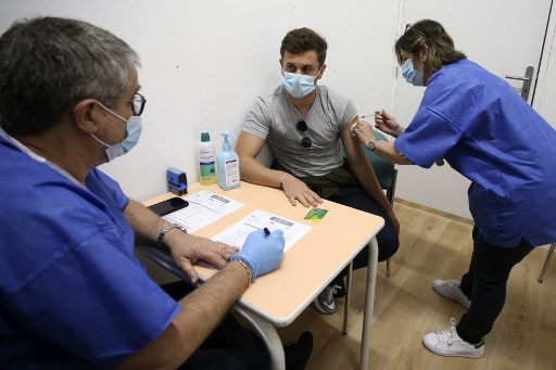 Un jeune homme de 21 ans reçoit une dose du vaccin Pfizer-BioNTech au centre de vaccination Baleone à Ajaccio sur l'île méditerranéenne française de Corse, le 13 mai 2021 (Photo, AFP)