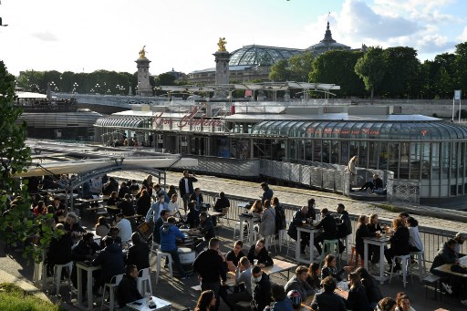 Les clients s'assoient en terrasse, à Paris, le 19 mai 2021 alors que les cafés, restaurants et autres commerces ont rouvert dans le cadre d'un assouplissement du confinement national en raison de la pandémie de Covid-19 (Photo, AFP)