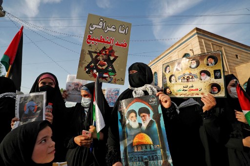 Des partisans des forces paramilitaires Hashed al-Shaabi (mobilisation populaire) portent des pancartes lors d'une manifestation dans la capitale Bagdad le 20 mai 2021, en soutien aux Palestiniens. (Ahmad Al-Rubaye / AFP)
