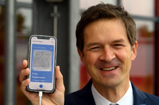 Ronald Fritz, chef de projet chez IBM, présente un téléphone portable avec le modèle d'un passeport de vaccination numérique (CovPass) lors d'un événement médiatique au centre de vaccination de Babelsberg à Potsdam près de Berlin, dans le nord-est de l'Allemagne, le 27 mai 2021, au milieu du nouveau coronavirus / Pandémie de covid19. (Soeren Stache / Pool / AFP)