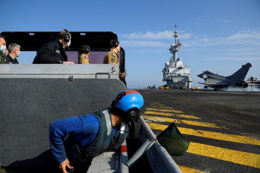 Le Premier ministre français Jean Castex (à gauche) regarde un chasseur à réaction Rafale atterrissant sur le porte-avions français Charles-de-Gaulle le 5 juin 2021, au large de Toulon, dans le sud de la France. NICOLAS TUCAT / AFP