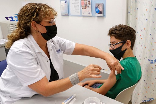 Michael, 12 ans, reçoit une dose du vaccin Pfizer/BioNTech aux services de santé Maccabi de la ville côtière de Tel Aviv le 6 juin 2021 (Photo, AFP)