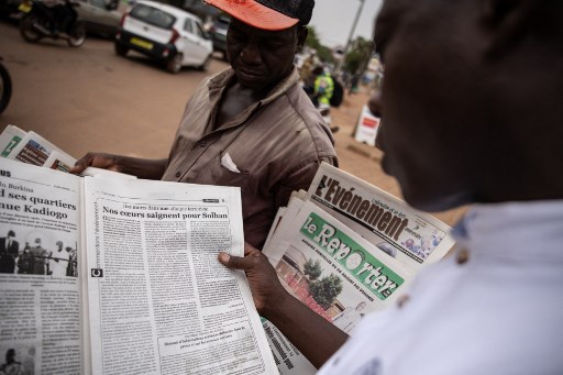 Un homme lit un article dans le journal L'Observateur Paalga à Ouagadougou le 7 juin 2021, sur les attentats survenus à Solhan (Photo, AFP)