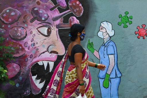 Un piéton passe devant une fresque murale représentant un personnel médical de première ligne arrêtant le coronavirus, à Navi Mumbai le 7 juin 2021 (Photo, AFP)