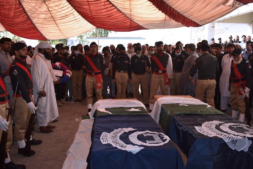 Des proches et des collègues se tiennent autour des cercueils de deux policiers, abattus alors qu'ils escortaient une équipe de vaccination contre la polio, lors des funérailles à Mardan le 9 juin 2021 (Photo, AFP)