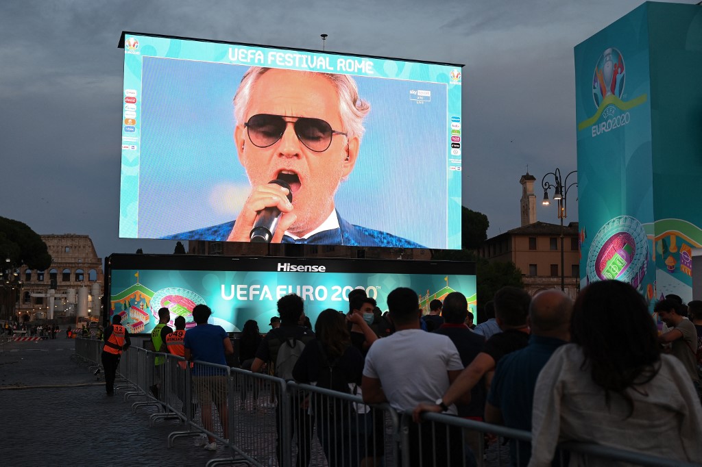 Les fans regardent sur un écran géant depuis une fan zone officielle au Forum romain de Rome le 11 juin 2021, la cérémonie d'ouverture du Championnat d'Europe de football EURO 2020 2021.(AFP)