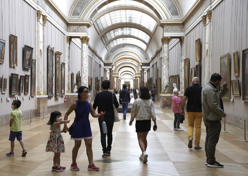 Dans cette photo d'archive prise le 06 juillet 2020, des visiteurs portant des masques faciaux circulent au musée du Louvre à Paris, le jour de la réouverture du musée. Le Premier ministre français Jean Castex a annoncé le 16 juin 2021 que les masques ne seront plus obligatoires hors de France à partir du 17 juin 2021.(François Guillot / AFP)