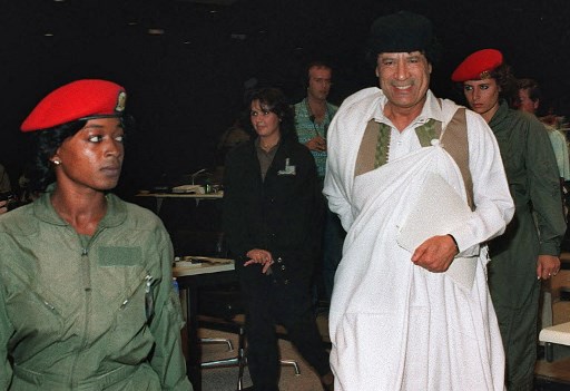Dans cette photo d'archive prise le 1er novembre 2008, le dirigeant libyen Mouammar Kadhafi (g), en visite à Moscou, est escorté par une garde du corps (d), de la brigade connue sous le nom d'Amazones. L'académie militaire de Tripoli, où les « Amazones » étaient formées, a longtemps été considérée comme un symbole du régime extravagant et capricieux du dictateur. (Alexandre Nemenov/AFP)