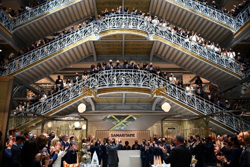 Le président français Emmanuel Macron (C) et les employés du grand magasin emblématique de Paris La Samaritaine applaudissent lors d'une cérémonie marquant la réouverture du magasin après 16 ans de fermeture, le 21 juin 2021 à Paris (Photo, AFP)