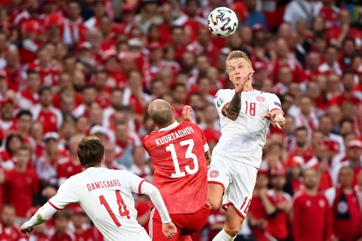 Foule de supporters derrière le défenseur danois Daniel Wass (d) et le russe Fedor Kudryashov lors du match de football du groupe B de l'UEFA EURO 2020 entre la Russie et le Danemark au stade Parken de Copenhague le 21 juin 2021. (Jonathan Nackstrand / Pool / AFP)