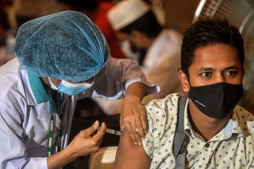 Un agent de santé inocule à un patient une dose du vaccin Oxford-AstraZeneca Covid-19 au Bangabandhu Sheikh Mujib Medical University Hospital (BSMMU), à Dhaka le 22 juin 2021. (Munir Uzzaman/AFP)
