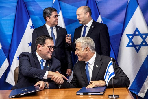 Le ministre israélien des Affaires étrangères Yair Lapid (en bas à droite), serre la main du Ministre hondurien des Affaires étrangères Lisandro alors que le Premier ministre israélien Naftali Bennett (en haut à droite) s'entretient avec le président hondurien Juan Orlando Hernandez lors de la signature d'accords bilatéraux au premier Bureau du ministre à Jérusalem le 24 juin 2021 (Photo, AFP)