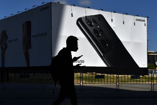 Un visiteur devant le site du Mobile World Congress (MWC) à Barcelone le 25 juin 2021. Le Mobile World Congress (MWC) de quatre jours, l'un des premiers grands forums technologiques organisés en Europe depuis le début de la pandémie, intervient alors que les ventes mondiales de smartphones rebondissent après avoir chuté en 2020 en raison des ravages économiques causés par la crise sanitaire. (Pau Barrena/AFP)