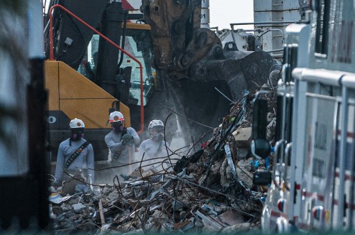 Les équipes de recherche et de sauvetage recherchent d'éventuels survivants dans l'immeuble à condos de 12 étages Champlain Towers South partiellement effondré le 28 juin 2021 à Surfside, en Floride (Photo, AFP)