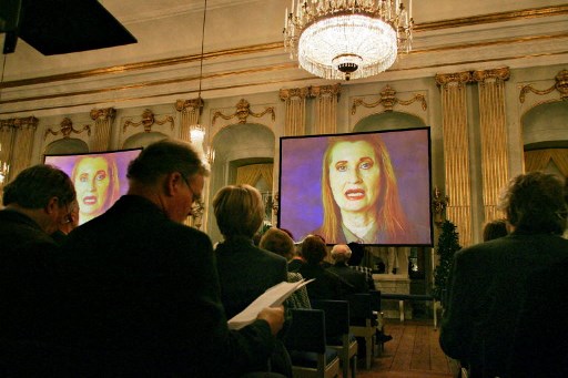 La lauréate du prix Nobel de littérature autrichienne Elfriede Jelinek (à l'écran) apparaît dans une conférence vidéo à l'Académie suédoise de Stockholm le 07 décembre 2004. Jelinek a été la première lauréate de littérature depuis l'Australien Patrick White en 1973 à ne pas venir à Stockholm pour la remise des prix. (Jonas Ekstromer / Scanpix Suède / AFP)