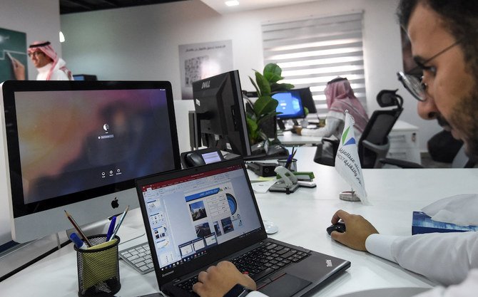 Une photo prise le 17 août 2017 montre un employé saoudien utilisant un ordinateur portable pour préparer un diaporama dans son bureau de Riyad (Fichier Photos/AFP)