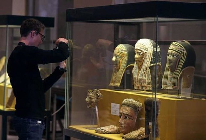 Un visiteur prend en photo des antiquités, restituées par l’Italie au musée égyptien du Caire, en Égypte, le 4 juillet 2018 (Reuters)