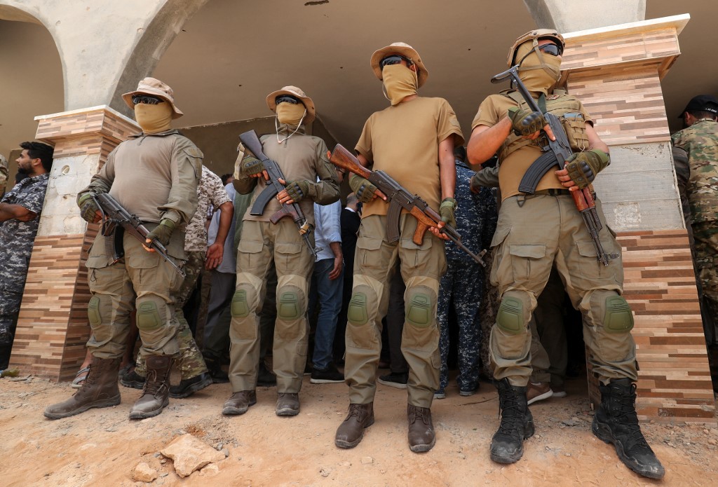Des combattants du gouvernement libyen d'entente nationale (GNA) montent la garde le 20 juin 2021 dans la ville de Buwairat al-Hassoun (AFP)