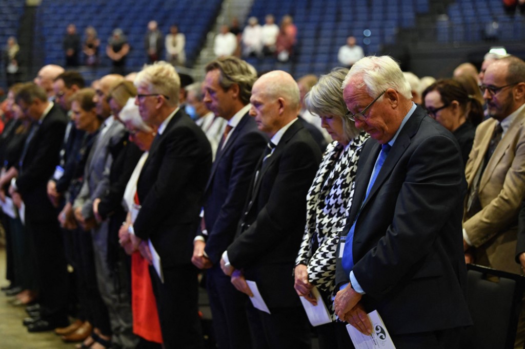 Les gens écoutent les noms des personnes qui ont perdu la vie dans les attaque.(AFP) es terroristes lors d'un service commémoratif national à Christchurch le 13 mars 2021