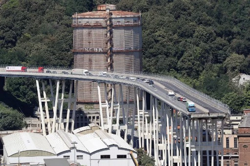 Cette vue générale prise le 15 août 2018 montre des véhicules abandonnés sur le pont autoroutier de Morandi au lendemain de l'effondrement d'une section dans la ville de Gênes, dans le nord-ouest de l'Italie. Au moins 38 personnes ont été tuées le 14 août, lorsque le pont autoroutier géant s'est effondré à Gênes, dans le nord-ouest de l'Italie.(Valéry Hache/AFP)