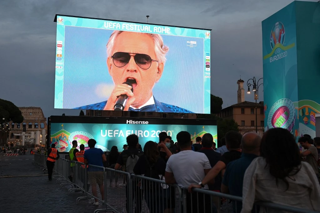 Les fans regardent sur un écran géant depuis une fan zone officielle au Forum romain de Rome le 11 juin 2021, la cérémonie d'ouverture du Championnat d'Europe de football EURO 2020 2021.(AFP)