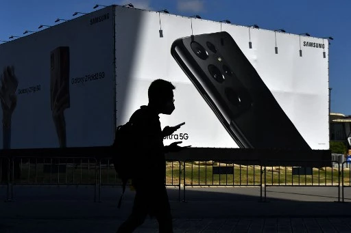 Un visiteur devant le site du Mobile World Congress (MWC) à Barcelone le 25 juin 2021. Le Mobile World Congress (MWC) de quatre jours, l'un des premiers grands forums technologiques organisés en Europe depuis le début de la pandémie, intervient alors que les ventes mondiales de smartphones rebondissent après avoir chuté en 2020 en raison des ravages économiques causés par la crise sanitaire. (Pau Barrena/AFP)