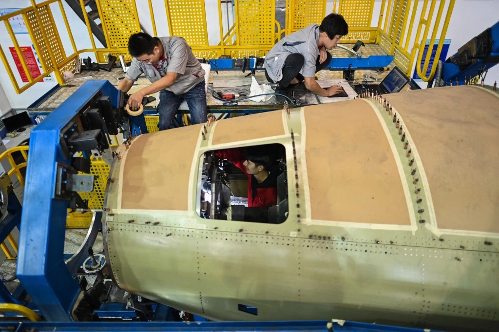 Des employés travaillent sur la section arrière du fuselage du Comac C919, la première compagnie aérienne à réaction commerciale de Chine (AFP)