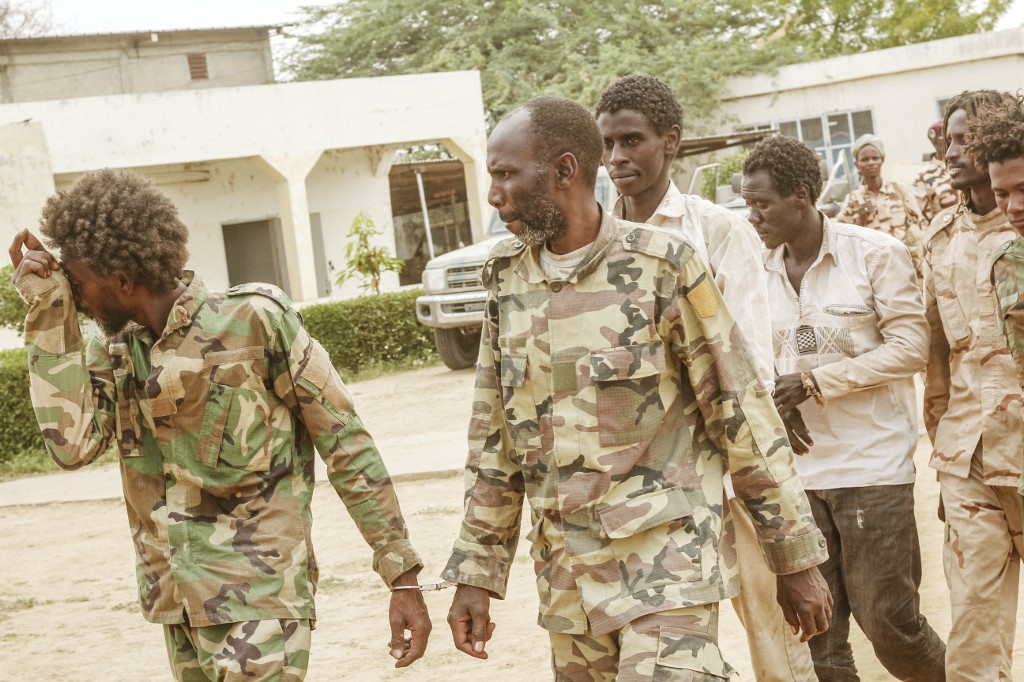 Un groupe de rebelles capturés du FACT (Front pour le changement et la concorde au Tchad) marche menotté alors qu'ils sont exposés avec leurs armes et véhicules confisqués (AFP)