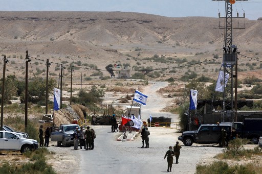 Des soldats israéliens se rassemblent au poste de contrôle de la frontière israélo-jordanienne près de Moshav Tsofar dans la vallée de l'Arava, au sud du bassin de la mer Morte, le 30 avril 2020. Les agriculteurs israéliens ne seront plus autorisés à entrer dans une enclave agricole en Jordanie voisine, suite à l'expiration du bail d'Israël sur les terres frontalières. (Menahem Kahana / AFP)