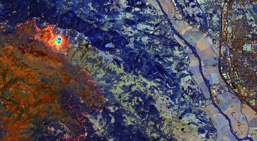 Cette image satellite infrarouge à ondes courtes (SWIR) haute résolution publiée par Maxar Technologies montre une végétation brûlée apparaissant dans une couleur rouille/orange tandis qu'une végétation saine apparaît dans des tons de bleu et des incendies actifs du LNU Lightning Complex Wildfire brûlant à l'ouest de Healdsburg, brillent en orange/jaune dans le comté de Sonoma, en Californie, le 20 août 2020. (Document / Image satellite ©2020 Maxar Technologies / AFP)