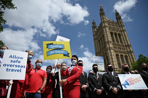 Des représentants de l'industrie du voyage, y compris le personnel de cabine et les pilotes des compagnies aériennes, manifestent lors d'une « Journée d'action sur les voyages » devant le Parlement dans le centre de Londres le 23 juin 2021. (Daniel Leal-Olivas/AFP)