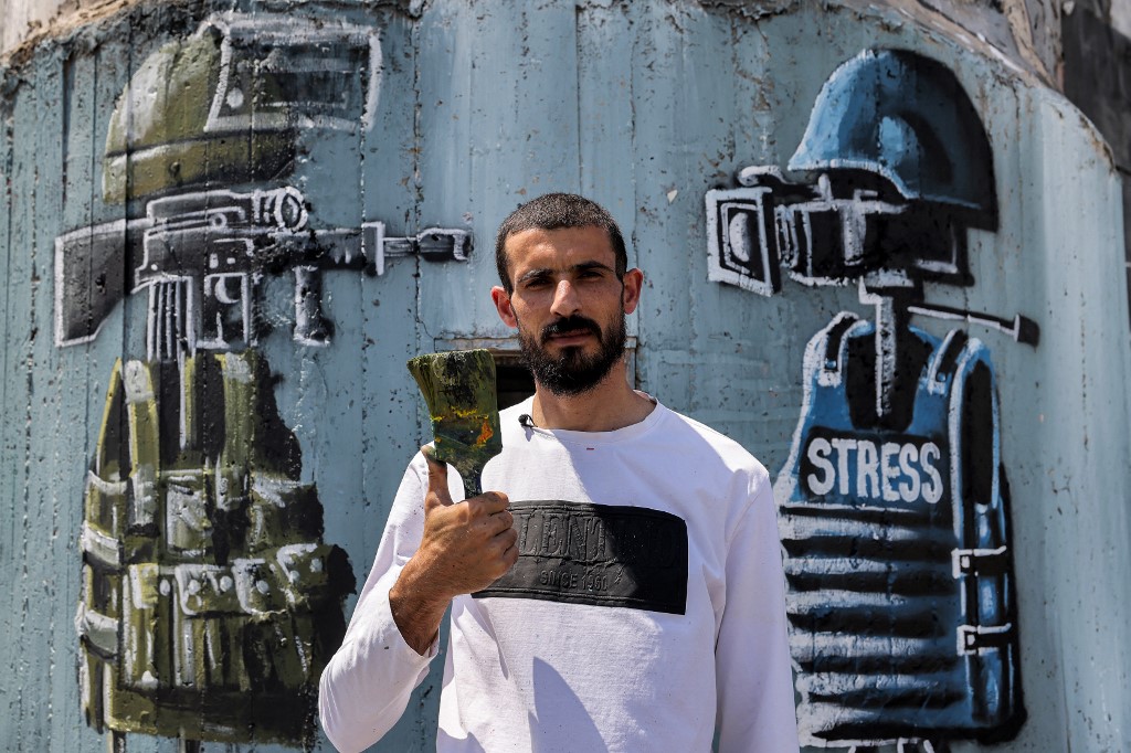 Les pinceaux d'un Palestinien sur le mur de séparation israélien pour dénoncer l'occupation