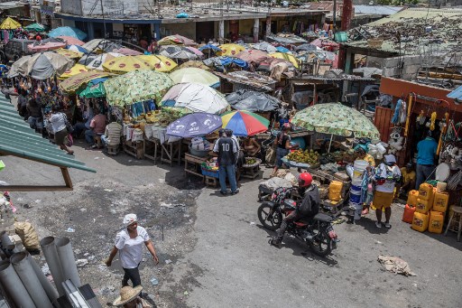 Vendeurs sous des parapluies au marché Salomon au centre-ville de Port-au-Prince le 13 juillet 2021, quelques jours après l'assassinat du président haïtien Jovenel Moise. (Valérie Baeriswyl / AFP)