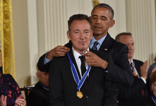 Dans cette photo d'archives prise le 22 novembre 2016, le président américain Barack Obama remet au chanteur Bruce Springsteen la Médaille présidentielle de la liberté, la plus haute distinction civile du pays, lors d'une cérémonie en l'honneur de 21 récipiendaires, dans l'East Room de la Maison Blanche à Washington, DC, le 22 novembre 2016. (Nicolas Kamm/AFP)