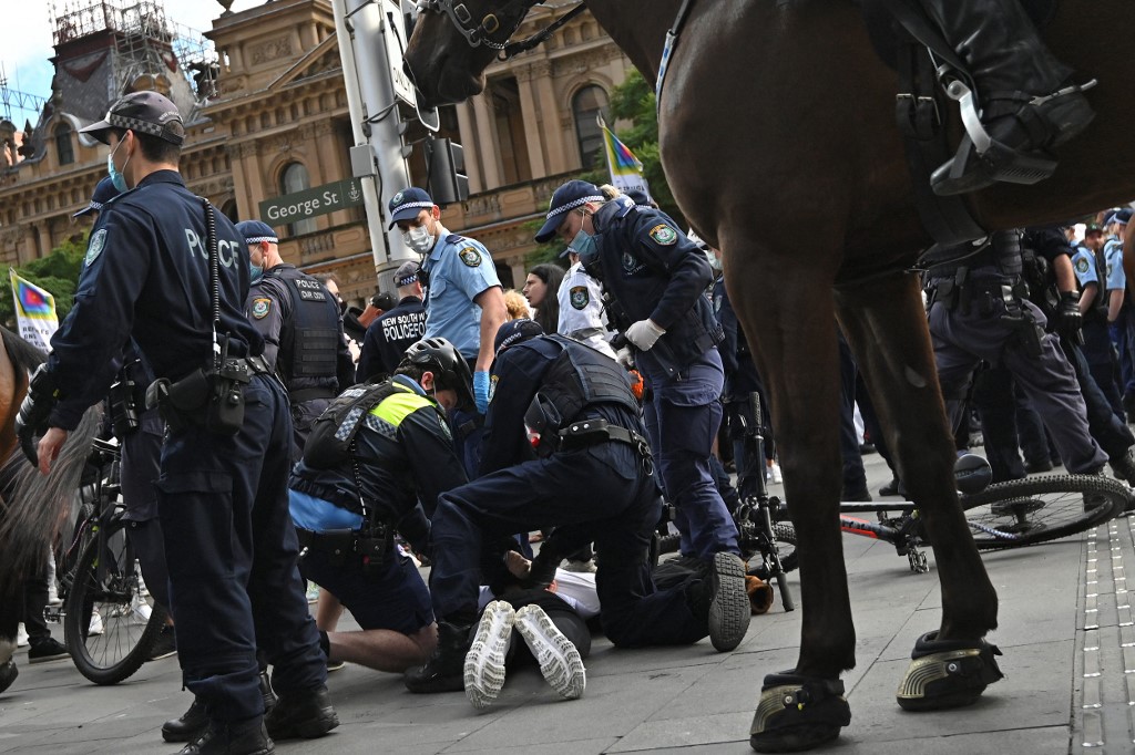 La police arrête un protestataire lors d'une manifestation anti confinement à Sydney le 24 juillet 2021. Photo AFP