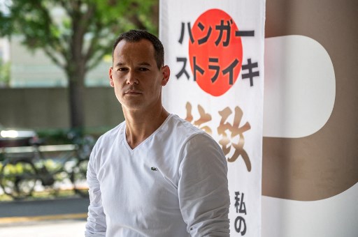 Dans cette photo d'archive prise le 10 juillet 2021, le résident français Vincent Fichot, dont les deux enfants ont été enlevés par leur mère japonaise, pose pour une photo suite à un entretien avec l'AFP au sujet de sa grève de la faim devant une gare. (Philippe Fong/AFP)