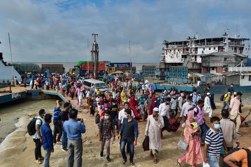 Les gens débarquent d'un ferry à Sreenagar le 31 juillet 2021 pour retourner dans leurs zones de travail après que le gouvernement du Bangladesh a assoupli les normes de verrouillage pour toutes les usines orientées vers l'exportation qui avaient été imposées auparavant pour freiner la propagation du coronavirus Covid-19. (Munir Uzzaman / AFP)