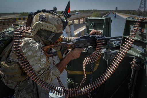 Un membre du personnel de sécurité monte la garde au sommet d'un véhicule à l'extérieur de l'enceinte du bureau de la Mission d'assistance des Nations Unies en Afghanistan (MANUA) dans le district de Guzara de la province de Herat le 31 juillet 2021. HOSHANG HASHIMI / AFP