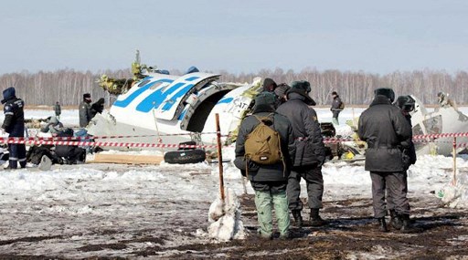 Une photo fournie le 2 avril 2012 par le département régional de Tioumen du ministère russe des Urgences montre des policiers debout près des débris d'un avion de ligne ATR-72 de fabrication franco-italienne de la compagnie aérienne privée russe UTair, sur le site de l'accident d'avion, à environ 45 km (28 miles) de la ville sibérienne occidentale de Tioumen. (AFP Photo/STR/Ministère russe des Urgences)