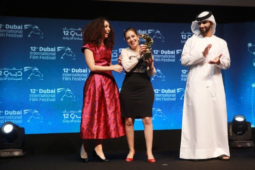 La réalisatrice tunisienne Leyla Bouzid (C) reçoit le prix Muhr de la meilleure fiction des mains du cheikh Mansoor bin Mohammed bin Rashid al-Maktoum lors de la cérémonie de clôture du Festival international du film de Dubaï le 16 décembre 2015 pour son film intitulé "Comme j'ouvre les yeux". (AFP/ STR)