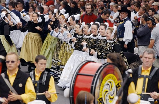 Des jeunes femmes en costumes traditionnels bretons exécutent une danse bretonne dans les rues de Lorient, le 07 août 2005, lors de la Grande Parade des nations celtes du festival interceltique de Lorient (FIL). (Frank Perry/AFP)