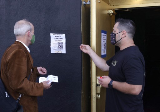 Un portier d'Oasis informe un client qu'une carte de vaccination est requise pour entrer dans le club le 29 juillet 2021 à San Francisco, Californie. (Justin Sullivan/Getty Images/AFP)